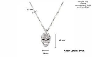 Vue détaillée d'un pendentif tête de mort en argent avec gravure fine sur chaîne à maillons