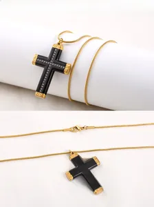 Detail showing the black cross pendant with gold engraving and inset white crystals