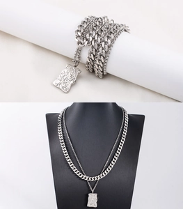 Double-layered silver Cuban chain necklace featuring an irregular lava texture pendant