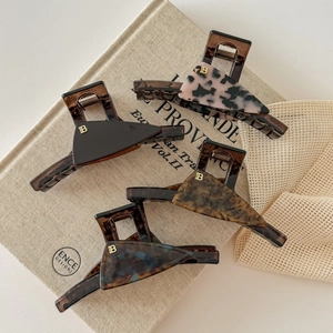 Set of four French acetate hair claws in various patterns with gold B metal accents