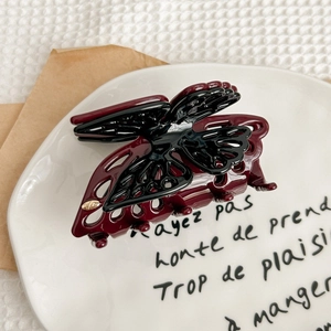 Detailed macro view of the premium burgundy butterfly hair claw with metallic gold accents