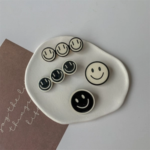 Lot de barrettes à cheveux sourire noir et blanc sur un plateau en céramique chic