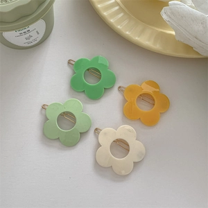 Set of four pastel flower hair clips in green, yellow, and white colors for women