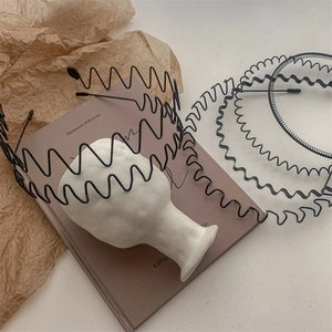 Set of black wave metal headbands for men and women on a stylish aesthetic pedestal