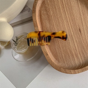 Detail of creative tortoiseshell acetate mini hair comb clip with amber textures