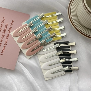 Set of 4 matte seamless hair clips for makeup styling on white fabric background