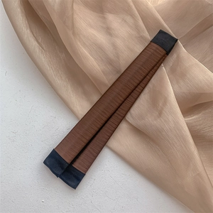 Vue détaillée du chignon magique marron avec une texture en tissu tissé fin