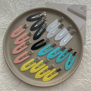 Set of colorful seamless hair clips in pastel pink, blue, yellow, and white on a tray