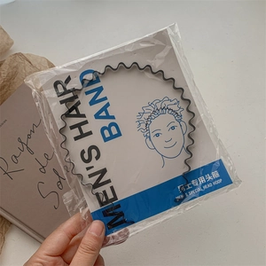 Close-up of black wave metal men's hair band in its original paper card packaging