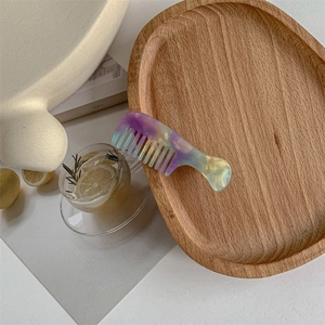 Detailed view of creative mini comb hair clip with purple and green marble resin texture