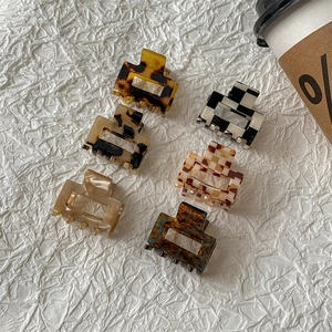 Set of six retro leopard and checkerboard acetate mini hair claws on white background