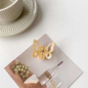 Detail of elegant cream marble butterfly hair claw clip with hollow wings design
