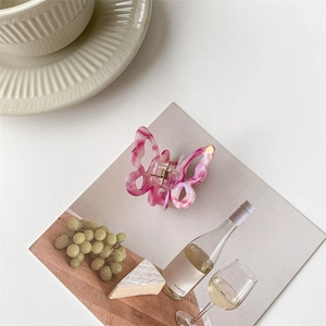 Detail of pink marble butterfly hair claw clip on an elegant French decorative card