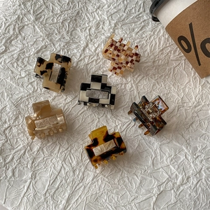 Set of 6 leopard and checkerboard acetate hair claws on a cozy white textured surface