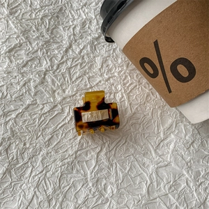 Macro detail of the small square acetate claw clip with tortoise shell pattern texture