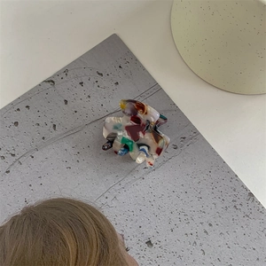 Detail view of multicolored marble acetate hair claw clip with a polished finish