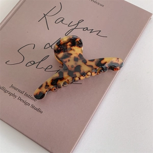 Detailed macro view of large tortoiseshell acetate hair claw clip with leopard pattern