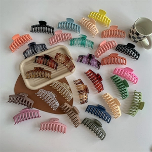 Collection of large shark hair clips in assorted matte and glossy colors on a white background