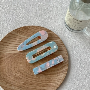 Ensemble de trois barrettes en acétate avec textures marbrées roses et bleues sur bois