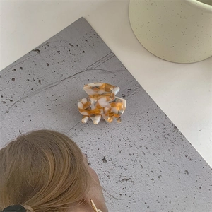 Detail view of small tortoiseshell acetate hair claw clip with smooth amber texture