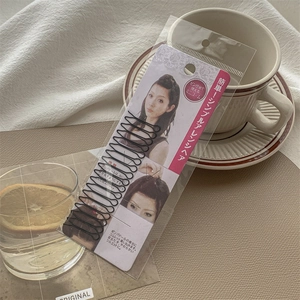 Detailed view of black metal hair styling clips with retail packaging instructions