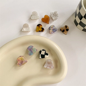 Elegant heart shaped acetate hair claws in various patterns like checkered and tortoiseshell