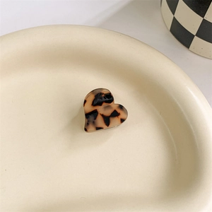 Macro shot of a heart-shaped acetate hair claw featuring classic tortoiseshell patterns