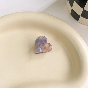 Detail of a mini heart-shaped acetate hair claw with purple and pink marble texture
