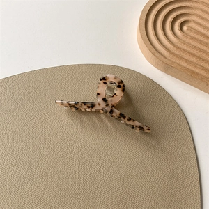 Close-up of tortoise shell pattern acetate hair claw clip with metallic spring detail