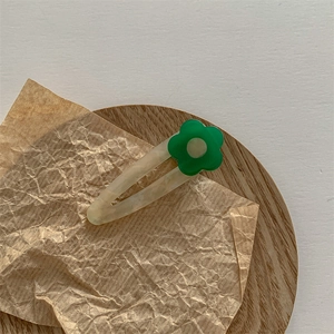 Vue macro d'une barrette en acétate avec texture marbrée sur un plateau en bois rustique