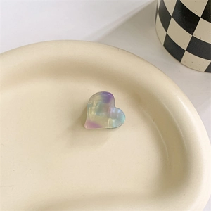 Detailed view of heart-shaped holographic hair clip with iridescent pastel gradient finish