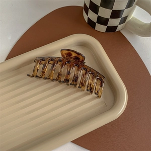 Detail of a large amber tortoiseshell hair claw clip with glossy finish and strong grip