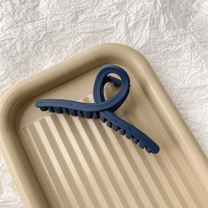 Détail macro de la pince à cheveux bleu foncé mat avec ses dents de préhension solides