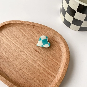 Close-up of blue and white checkerboard heart-shaped hair clip on a wooden tray