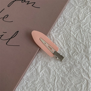 Detail of pink matte hair clip on aesthetic background for fringe styling