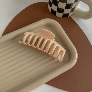 Matte beige hair claw clip for thick hair displayed on an elegant aesthetic tray