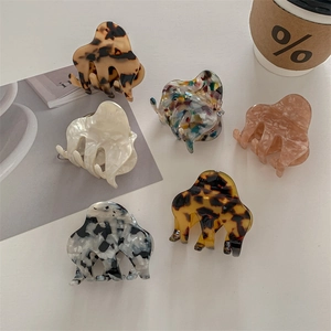 Elegant small acetate hair claws in various marble patterns for stylish women