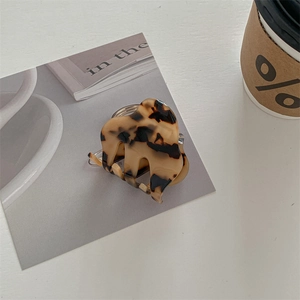 Detail shot of a small leopard print hair claw clip made from high quality acetate material