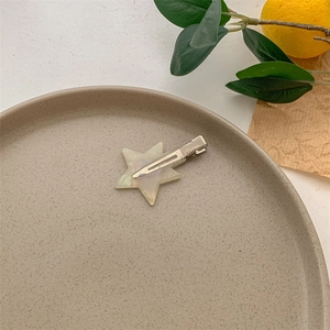 Detailed close-up of a star-shaped acetate hair clip with pearlescent marble texture