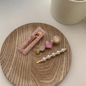 Vue détaillée du lot de trois barrettes en perles et acrylique sur un plateau en bois