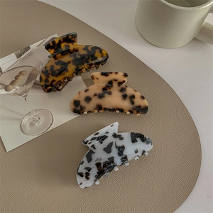 Three-piece large leopard acetate hair claws in tortoise shell patterns on beige background