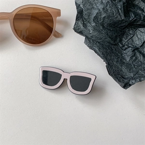 Détail d'une broche créative en forme de lunettes roses avec finition en émail brillant