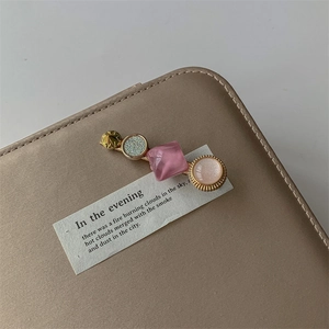 Detail of sweet geometric hair clip with gold star and pink resin on a leather bag