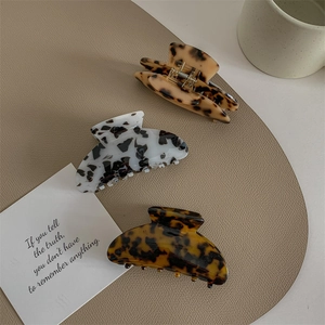 Three-piece acetate hair claw clip set with elegant leopard and tortoiseshell patterns