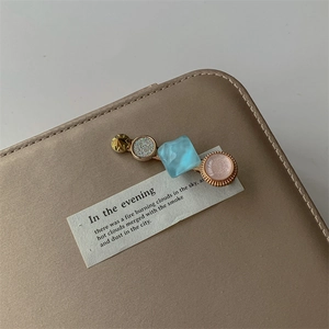 Detail of elegant bobby pin with gold star, blue gemstone, and pink pearl accents