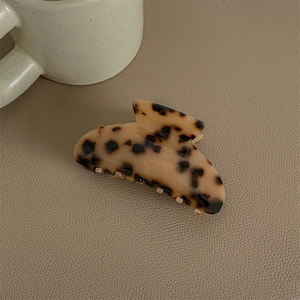 Close-up of leopard print acetate hair claw clip with a glossy tortoise pattern