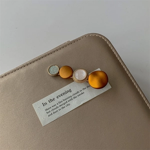 Detail of elegant orange hair clip with faux pearl and silver glitter circle accents