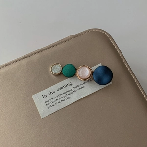 Detail of elegant hair clip with four colorful round beads on a stylish gold texture