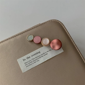 Detailed shot of a pearl hair clip featuring four colorful round elements on satin