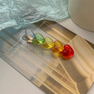 Nahaufnahme einer regenbogenfarbenen Haarklammer mit fünf Herzen und Goldlegierung